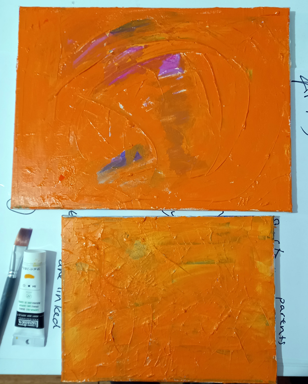 A photograph of two stretched canvasses covered with Cadmium Orange paint.